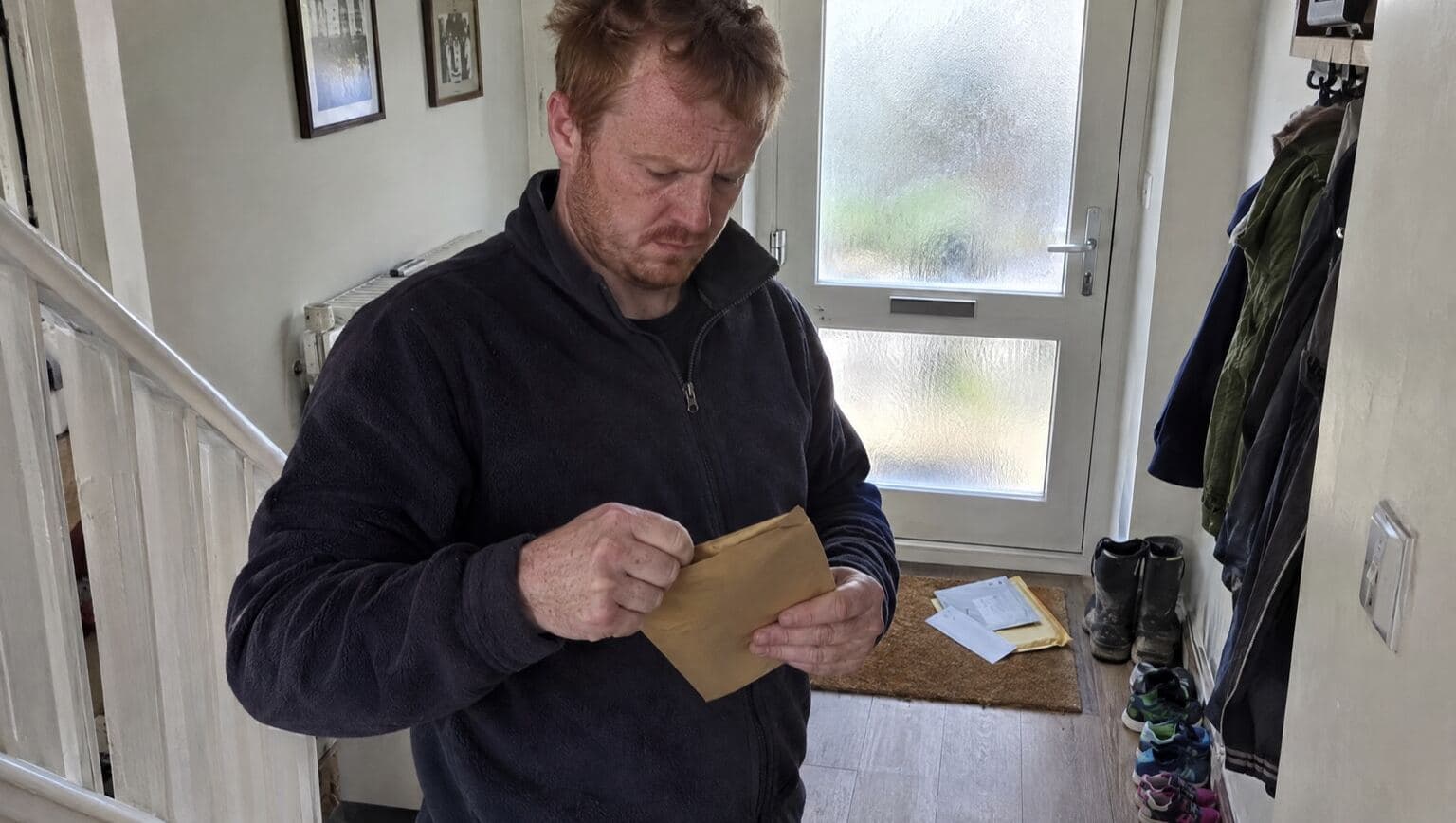 A company director opening an official letter at home