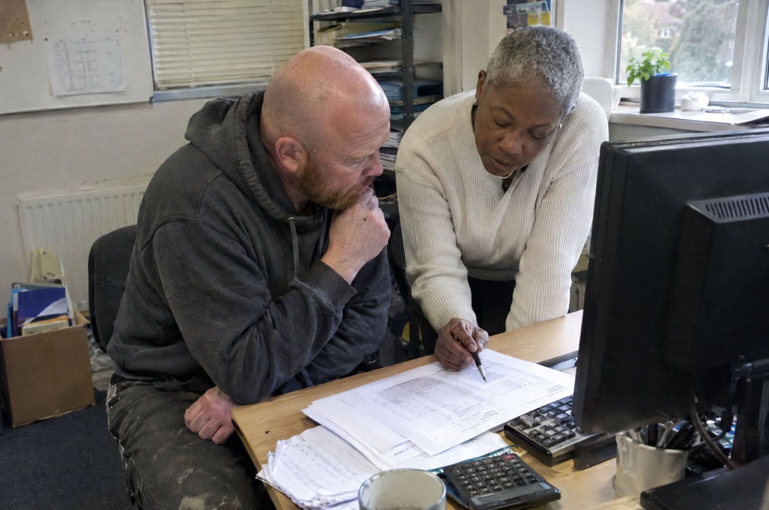 A business owner and accountant reviewing monthly records