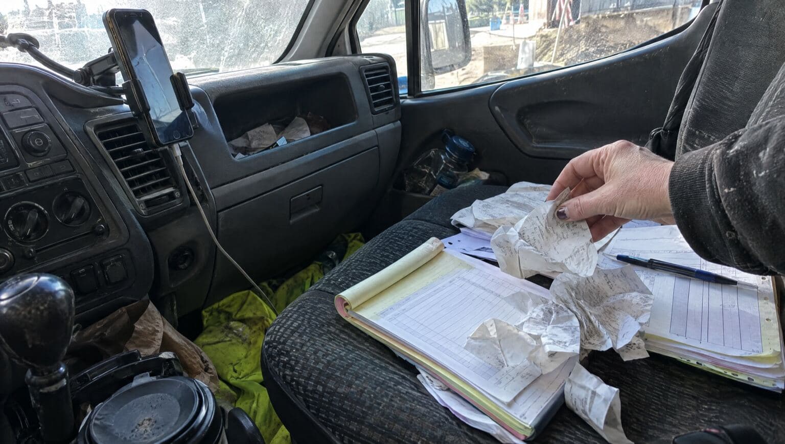A van dashboard covered in receipts and paperwork